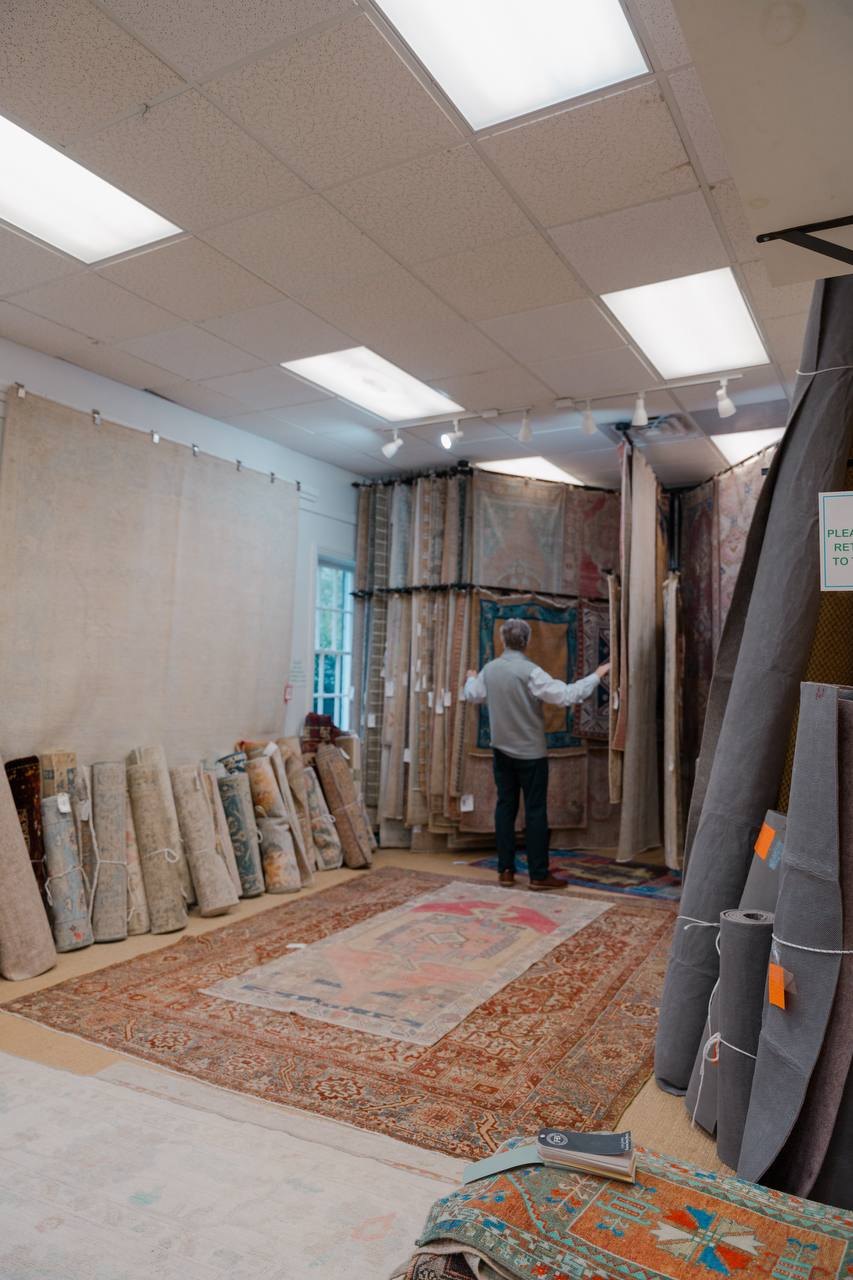 Tom hanging a rug in the Dwyer Rugs shop