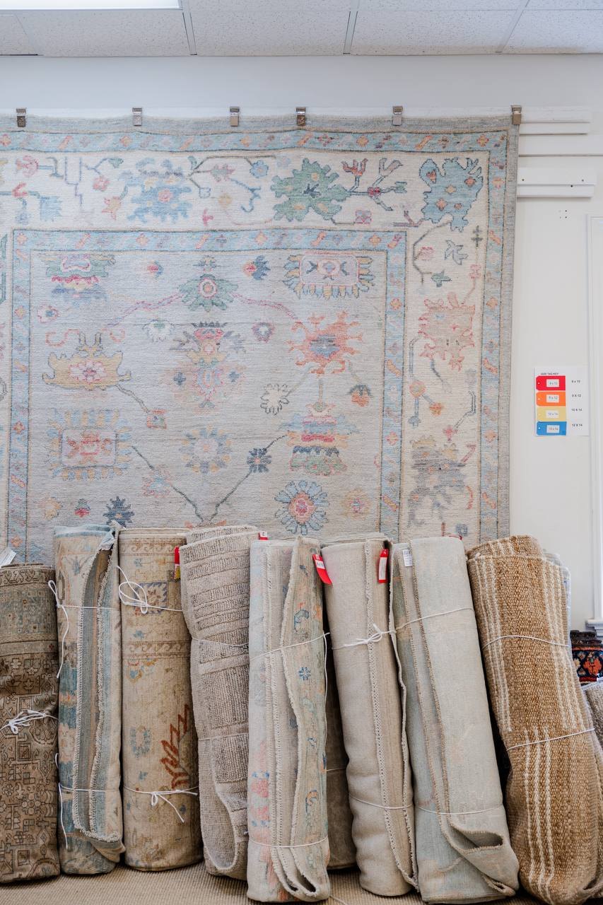 An Oushak rug on the wall at the shop